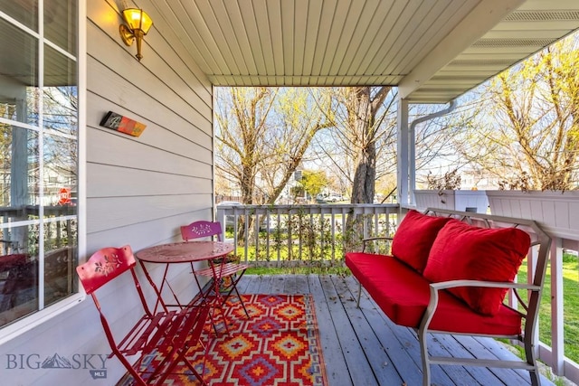 wooden deck with outdoor lounge area and fence
