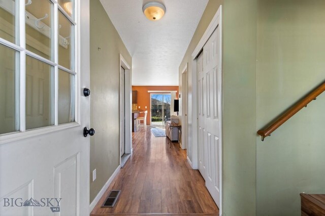 corridor featuring hardwood / wood-style flooring and baseboards