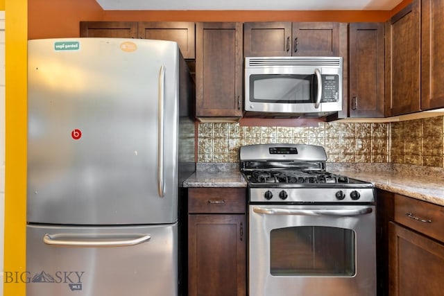 kitchen featuring appliances with stainless steel finishes, tasteful backsplash, dark brown cabinets, and light stone countertops