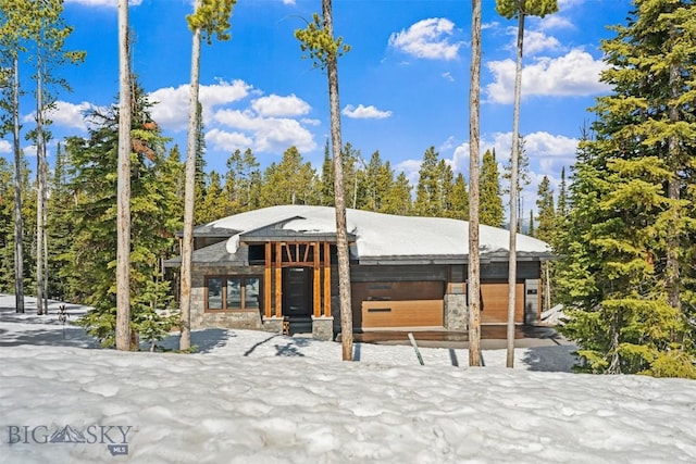 modern home featuring stone siding and a garage