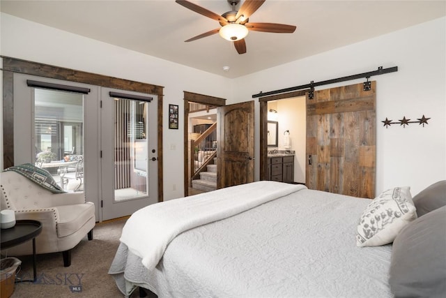 bedroom with access to exterior, a barn door, carpet flooring, and ceiling fan