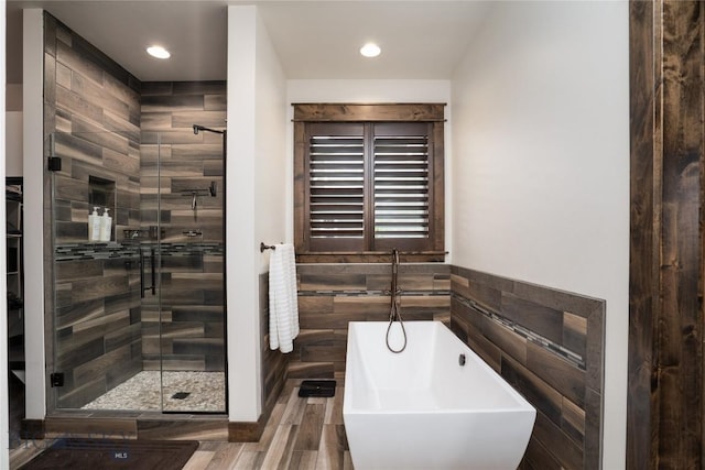 full bath with wine cooler, a shower stall, a soaking tub, tile walls, and recessed lighting