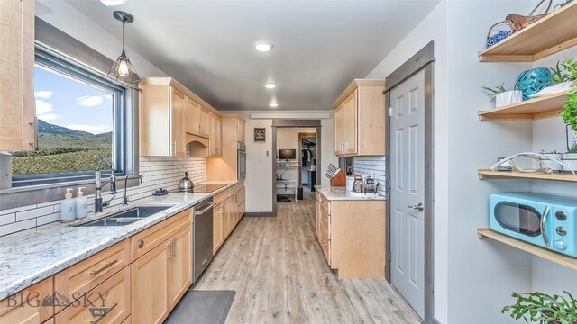 2200 Sugarloaf Mountain Rd, Glen, MT 59732 - kitchen with light brown cabinets, appliances with stainless steel finishes, a sink, light wood finished floors, and backsplash