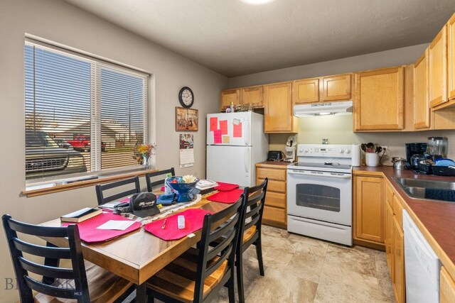 500/502 Idaho St, Belgrade, MT 59714 - kitchen featuring white appliances, under cabinet range hood, a sink, light brown cabinets, and stone finish flooring