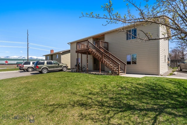 500/502 Idaho St, Belgrade, MT 59714 - view of front of house featuring stairway, a front yard, and a wooden deck