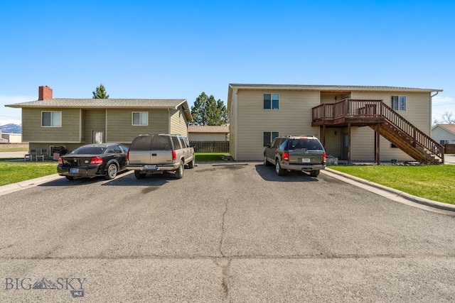500/502 Idaho St, Belgrade, MT 59714 - view of front of house featuring stairway, uncovered parking, a wooden deck, and a chimney