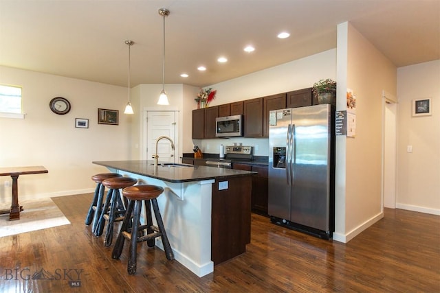 13 Ramshorn Peak Ln, Bozeman, MT 59718 - kitchen featuring stainless steel appliances, dark countertops, dark brown cabinetry, a breakfast bar, and a center island with sink