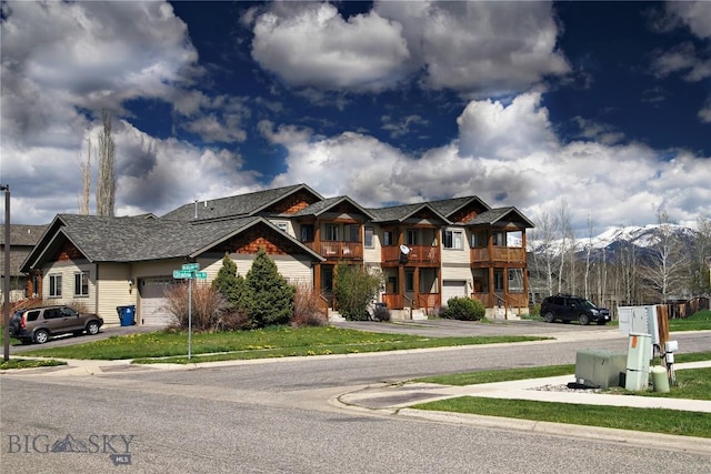 view of front facade featuring a mountain view, a balcony, and an attached garage
