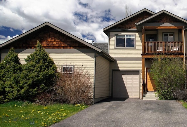 craftsman-style home with driveway, a balcony, and a garage