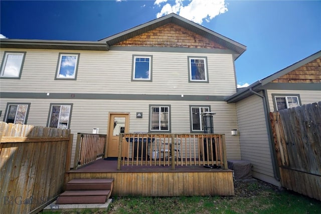 back of house featuring fence and a deck