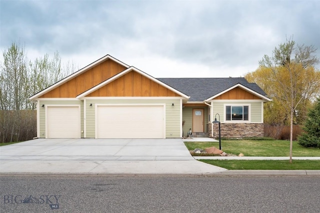 craftsman house with an attached garage, concrete driveway, a front lawn, roof with shingles, and board and batten siding