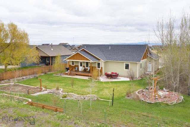 rear view of property with a garden, a wooden deck, a patio area, a shingled roof, and an outdoor living space