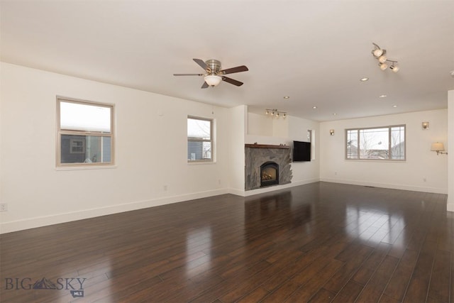 unfurnished living room featuring plenty of natural light, a ceiling fan, baseboards, a fireplace, and recessed lighting