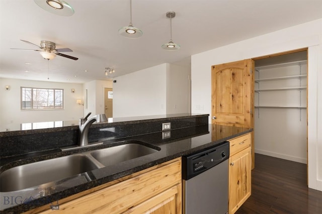 kitchen with stainless steel dishwasher, ceiling fan, a sink, dark stone counters, and dark wood-style flooring