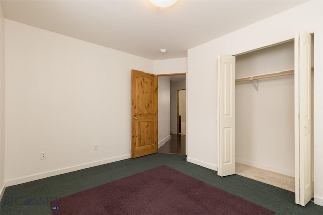 unfurnished bedroom featuring dark colored carpet, baseboards, and a closet