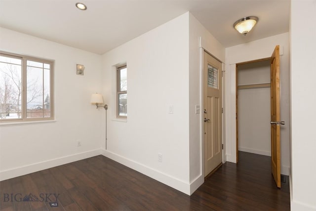 unfurnished bedroom featuring dark wood-style flooring, baseboards, and recessed lighting