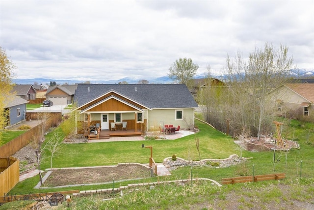 rear view of property with a deck, a patio area, a garden, board and batten siding, and roof with shingles