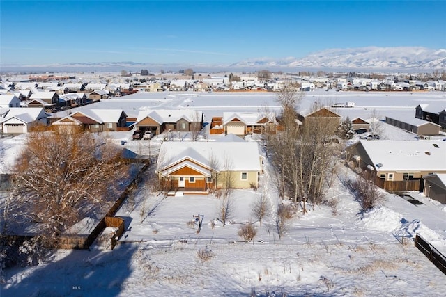 snowy aerial view featuring a residential view and a mountain view