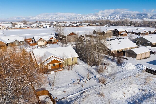 snowy aerial view featuring a residential view and a mountain view