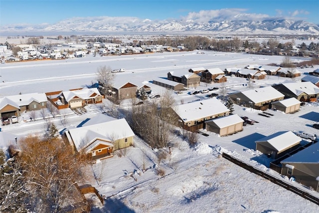 snowy aerial view featuring a residential view and a mountain view