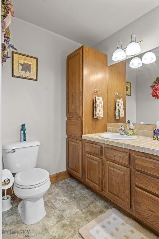 3450 W Hollyhock Dr, Belgrade, MT 59714 - bathroom featuring toilet, vanity, and baseboards