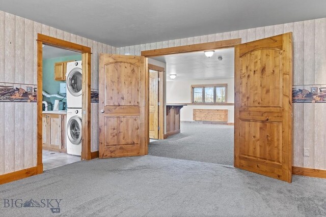 3450 W Hollyhock Dr, Belgrade, MT 59714 - washroom with stacked washing machine and dryer, cabinet space, and carpet floors