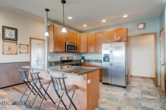 kitchen with appliances with stainless steel finishes, a breakfast bar area, pendant lighting, baseboards, and recessed lighting