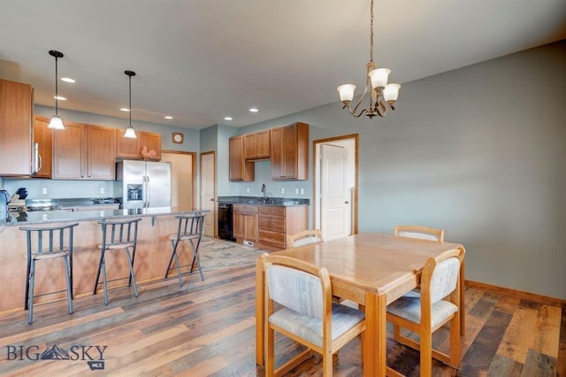dining area with a chandelier, light wood-style floors, recessed lighting, and baseboards