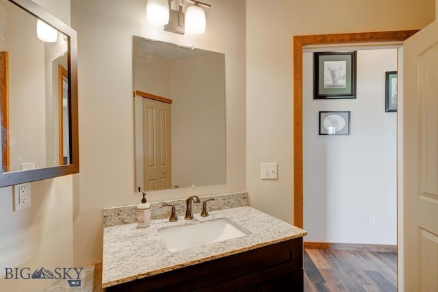 bathroom featuring wood finished floors, vanity, and baseboards