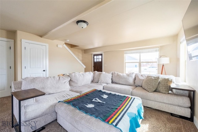 living area featuring carpet flooring, beamed ceiling, and stairs