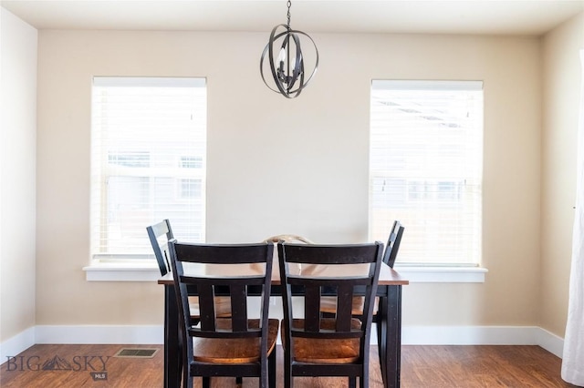 dining room featuring baseboards, wood finished floors, and plenty of natural light