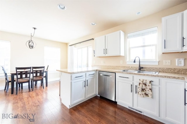 kitchen featuring dishwasher, a sink, a peninsula, white cabinetry, and dark wood-type flooring