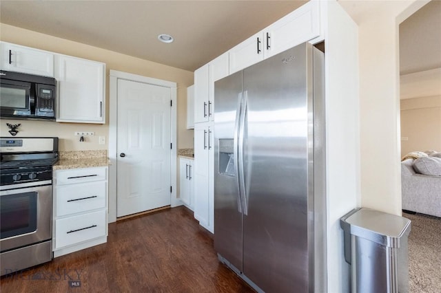 kitchen featuring appliances with stainless steel finishes, white cabinetry, dark wood-style flooring, light stone countertops, and recessed lighting
