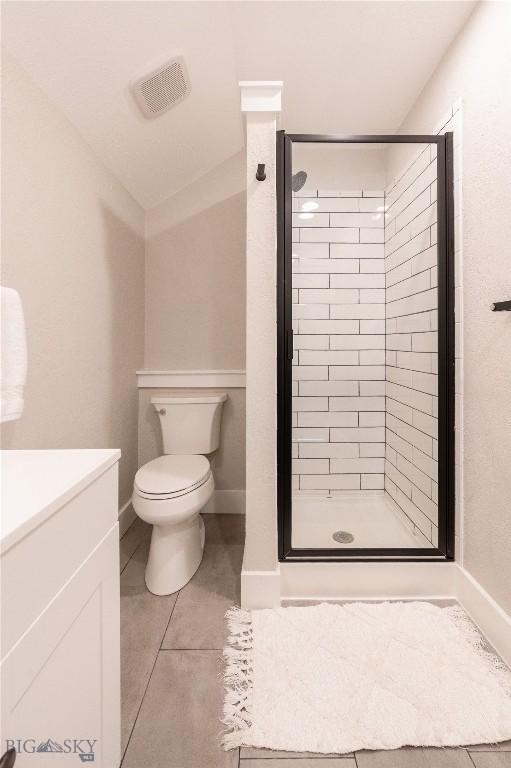 bathroom featuring a shower stall, tile patterned flooring, toilet, and baseboards