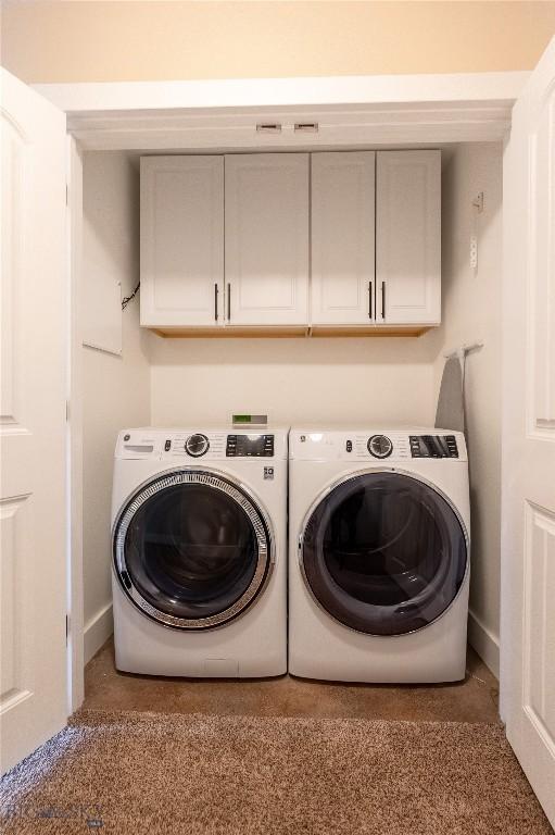 laundry room featuring independent washer and dryer and cabinet space