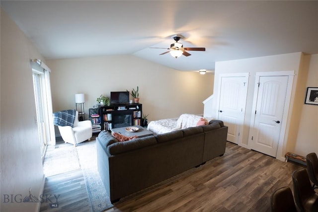 living room with ceiling fan, wood finished floors, and vaulted ceiling