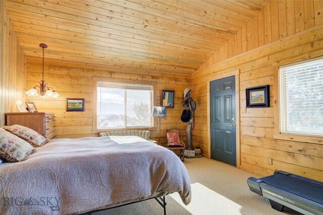 101 Deerfoot Trl, Ennis, MT 59729 - bedroom with multiple windows, wooden walls, lofted ceiling, carpet floors, and a chandelier
