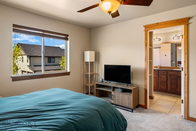 carpeted bedroom with ensuite bath, a ceiling fan, baseboards, and tile patterned floors