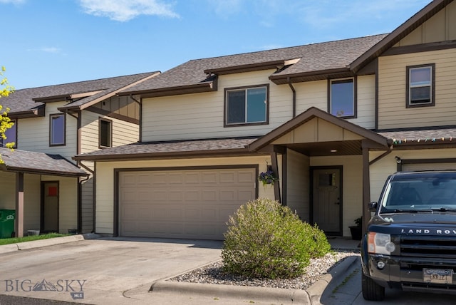 view of property with a garage, a shingled roof, concrete driveway, and board and batten siding