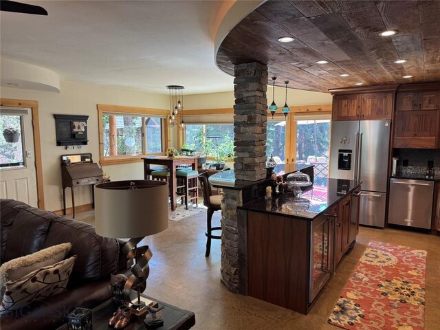 31 Basin Creek Rd, Boulder, MT 59631 - kitchen featuring appliances with stainless steel finishes, ornate columns, decorative light fixtures, a breakfast bar, and open floor plan