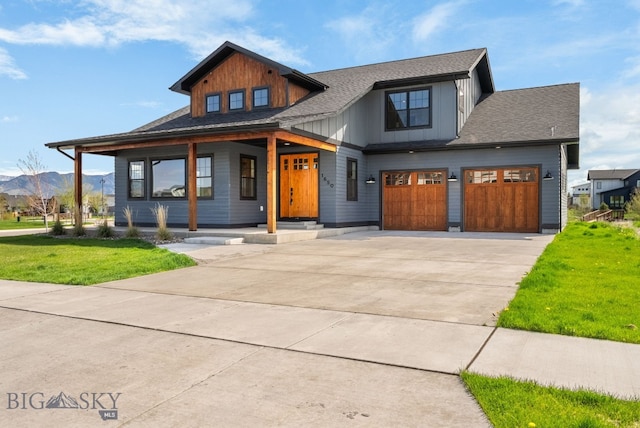 1650 Windrow, Bozeman, MT 59718 - view of front of property featuring covered porch, concrete driveway, a front yard, a mountain view, and a garage