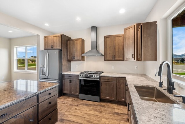 1650 Windrow, Bozeman, MT 59718 - kitchen with stainless steel appliances, wall chimney exhaust hood, a sink, light stone countertops, and healthy amount of natural light