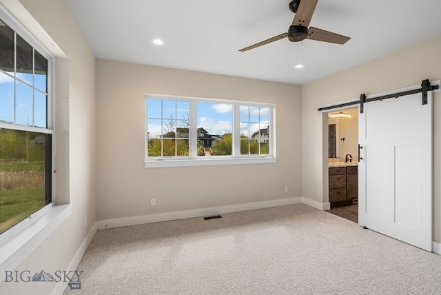 1650 Windrow, Bozeman, MT 59718 - unfurnished bedroom with a barn door, dark colored carpet, recessed lighting, baseboards, and ensuite bath