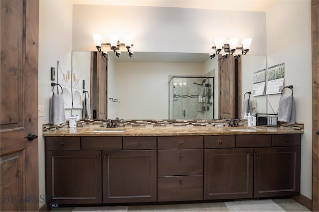 bathroom featuring a shower stall, double vanity, and a chandelier