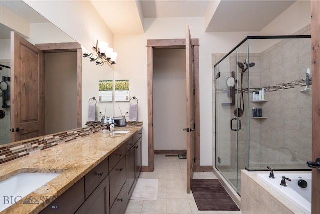bathroom featuring a shower stall, a bath, double vanity, tile patterned floors, and baseboards