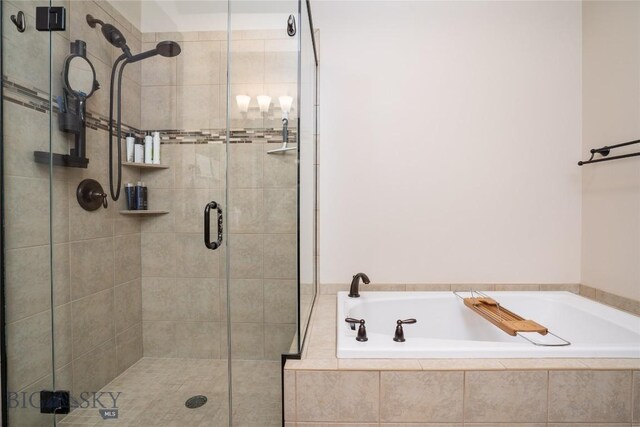 bathroom with a shower stall and a bath