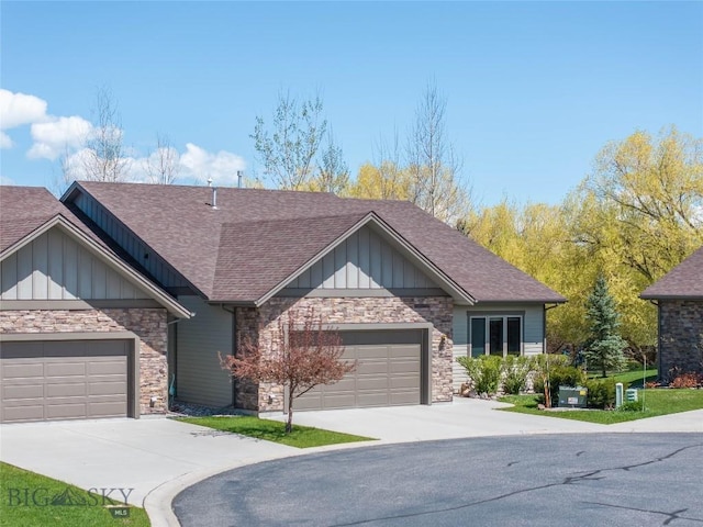 view of front of home featuring board and batten siding, roof with shingles, driveway, a garage, and stone siding