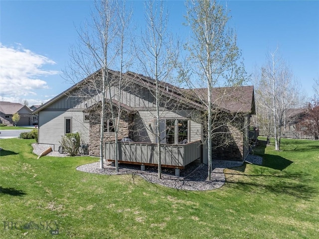 back of property featuring a lawn, a wooden deck, and board and batten siding