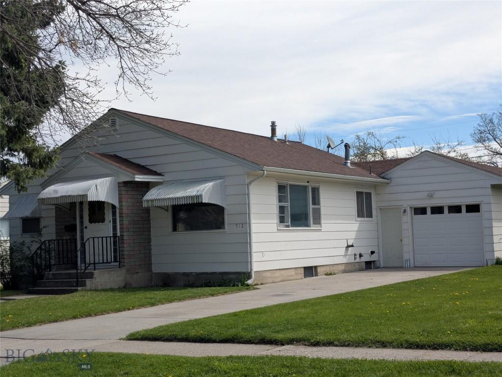 view of front facade featuring concrete driveway, a front lawn, an attached garage, and a shingled roof