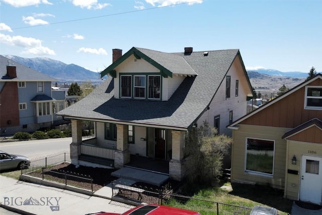 1100 Caledonia St, Butte, MT 59701 - view of front of home featuring a porch, a chimney, a fenced front yard, and roof with shingles